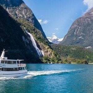 a small boat in a body of water with a mountain in the background