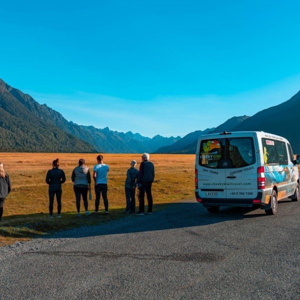 a group of people standing in front of a mountain