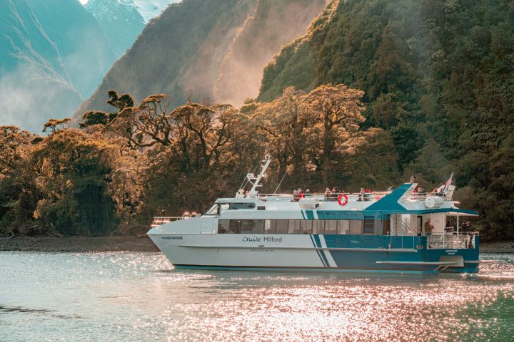 a small boat in a body of water with a mountain in the background