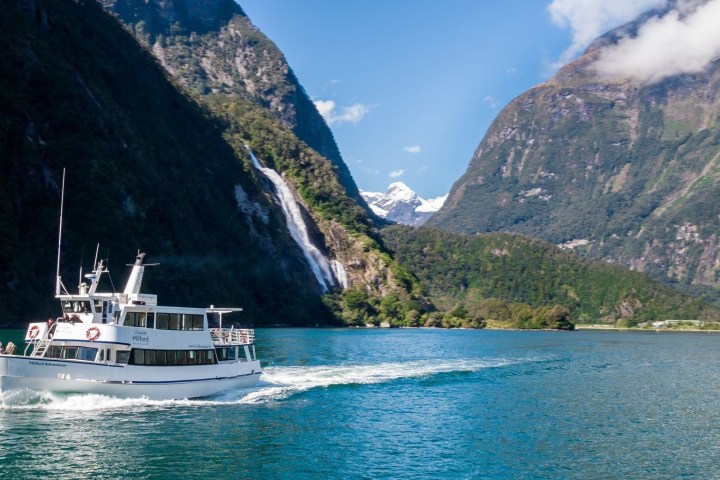 a small boat in a body of water with a mountain in the background