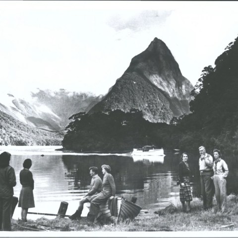 a group of people standing in front of a mountain