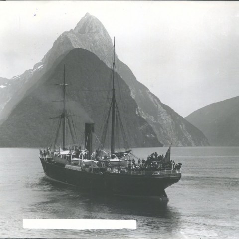 a boat in the water with a mountain in the background