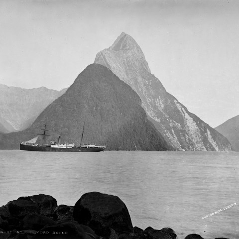 a large body of water with a mountain in the background
