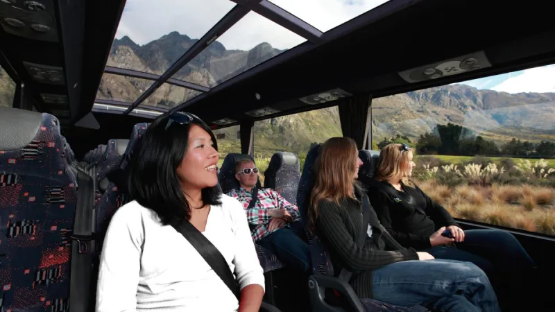 glass-roof-bus-to-milford-sound-1200×800 a group of people sitting at a train station